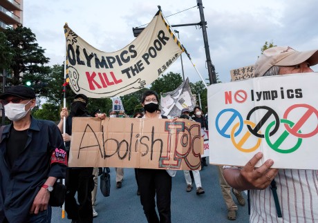 Opposition to the Tokyo Games is becoming more fervent in the host nation as protesters hold up signs while marching in front of Tokyo’s National Stadium. Photo: DPA
