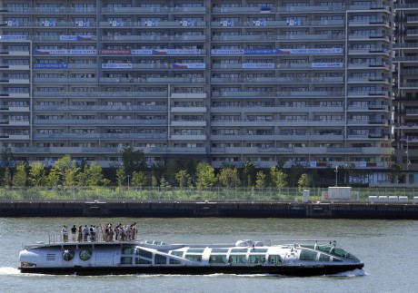 A tourist ship cruises past the Olympic Village buildings in Tokyo, where the first Covid-19 case was detected on Saturday. Photo: EPA