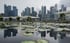 Singapore’s financial district skyline is seen reflected in a lotus pond on April 28. Photo: EPA