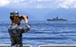 A soldier looks through binoculars during PLA Navy combat exercises and training in the waters around Taiwan on Friday. Photo: Xinhua
