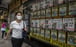 A woman walks past a property agent in Hong Kong on May 13, 2022. Recent US rate increases have come at a bad time for Hong Kong which, thanks to its dollar peg, must follow suit despite its own flagging economy. Photo: AFP