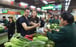 Tim Clancy (left) of Australia, a resident for six years in the Zhejiang provincial capital of Hangzhou, takes his American friend (centre) to a vegetable market where he pays for vegetables through mobile payment on April 14, 2017. Photo: Xinhua