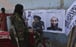 A Taliban fighter looks at Taliban flags and posters of leaders in Kabul. Photo: AP
